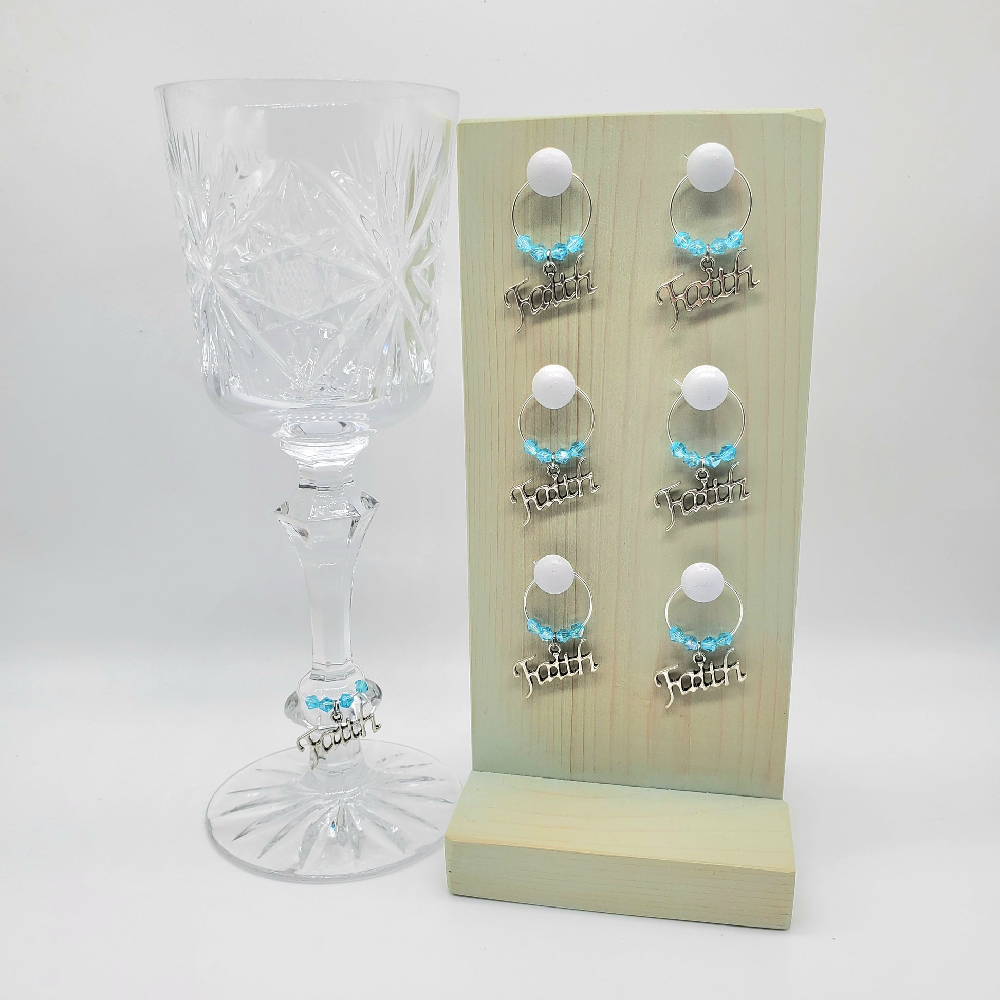 faith wine charms on a glass with aqua color crystal beads and wooden holder